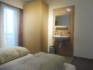 A hotel room with two beds, a bathroom with a sink and mirror, and a window with curtains. - Theresli Appartement/Fewo 6 Bettwohnung by Interhome (Saas-Almagell)