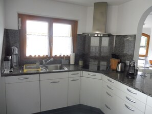 A modern kitchen with a double sink, stainless steel appliances, and white cabinetry. - Theresli Appartement/Fewo 6 Bettwohnung by Interhome (Saas-Almagell)