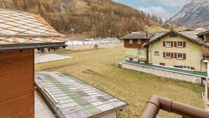 A mountain view with a sports field, buildings, and a wooden structure. - Haus Astoria Studio Apt # 6 by Interhome (Saas-Grund)