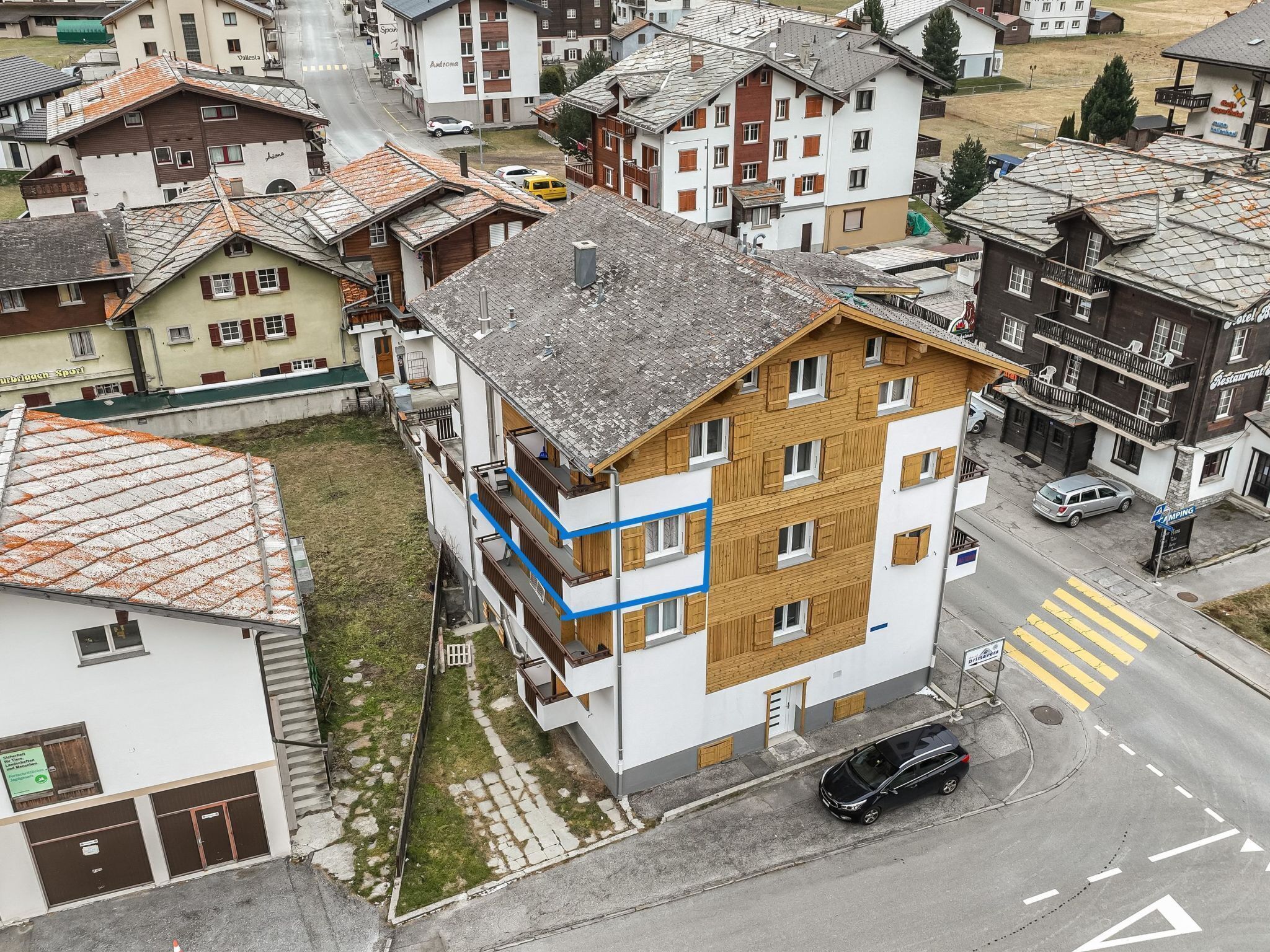 Un immeuble à plusieurs étages comprenant des espaces résidentiels et commerciaux, notamment un restaurant bien visible et un hôtel.