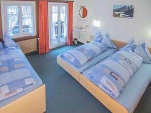 A hotel room with two beds, a bathroom, and a window with curtains. - Chalet Alpenruh Appartement/Fewo Nr. 2 Mittaghorn by Interhome (Saas-Fee)