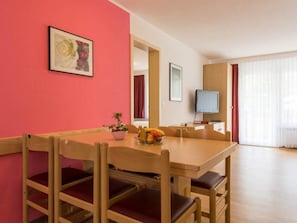 A dining area with a wooden table and chairs, a fruit bowl, and a potted plant. - Aiglon Appartement/Fewo 6-Bettwohnung Nr. 3 by Interhome (Saas-Fee)