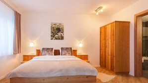 Ein Schlafzimmer mit einem hölzernen Bett, zwei Nachttischlampen, einem Wandbild und einem Holzschrank.