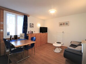 A compact living space with a dining area, a television, and a small seating area. - Chalet Ideal Appartement/Fewo 3-Bettwohnung Nr. 3 by Interhome (Saas-Fee)