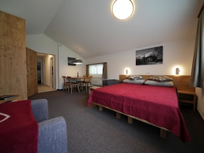 A hotel room with a bed, a desk, a chair, and a dining table. - Aida Appartement/Fewo 4-Bettwohnung by Interhome (Saas-Fee)
