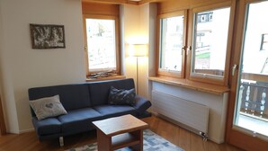 Een gezellige woonkamer met een bank, een bijzettafeltje en een lamp.