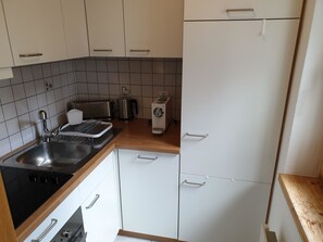 A compact kitchen with a sink, stove, toaster, kettle, and a refrigerator. - Achat Appartement/Fewo 4-Bettwohnung Nr. 3 by Interhome (Saas-Fee)