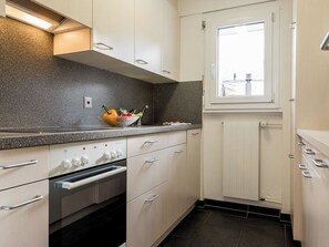 Eine moderne Küche mit einer Granitabdeckung, Edelstahlgeräten und einem Fenster über der Spüle.