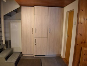Habitació amb armari de paret, una porta i una escala.