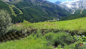 A mountainous landscape with a clear sky, a suspension bridge, and a stone wall. - Amedee Appartement/Fewo 5-Bettwohnung Nr. 1 by Interhome (Saas-Fee)
