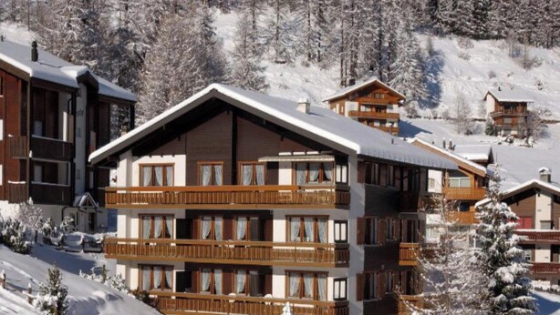 A multi-story chalet with balconies, set in a snowy mountainous area. - Amedee Appartement/Fewo 5-Bettwohnung Nr. 1 by Interhome (Saas-Fee)