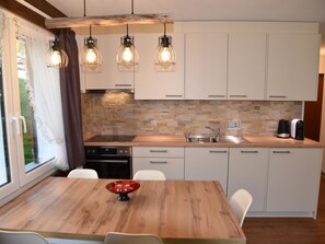 A modern kitchen with white cabinets, a wooden countertop, and a built-in oven. - Amedee Appartement/Fewo 5-Bettwohnung Nr. 1 by Interhome (Saas-Fee)