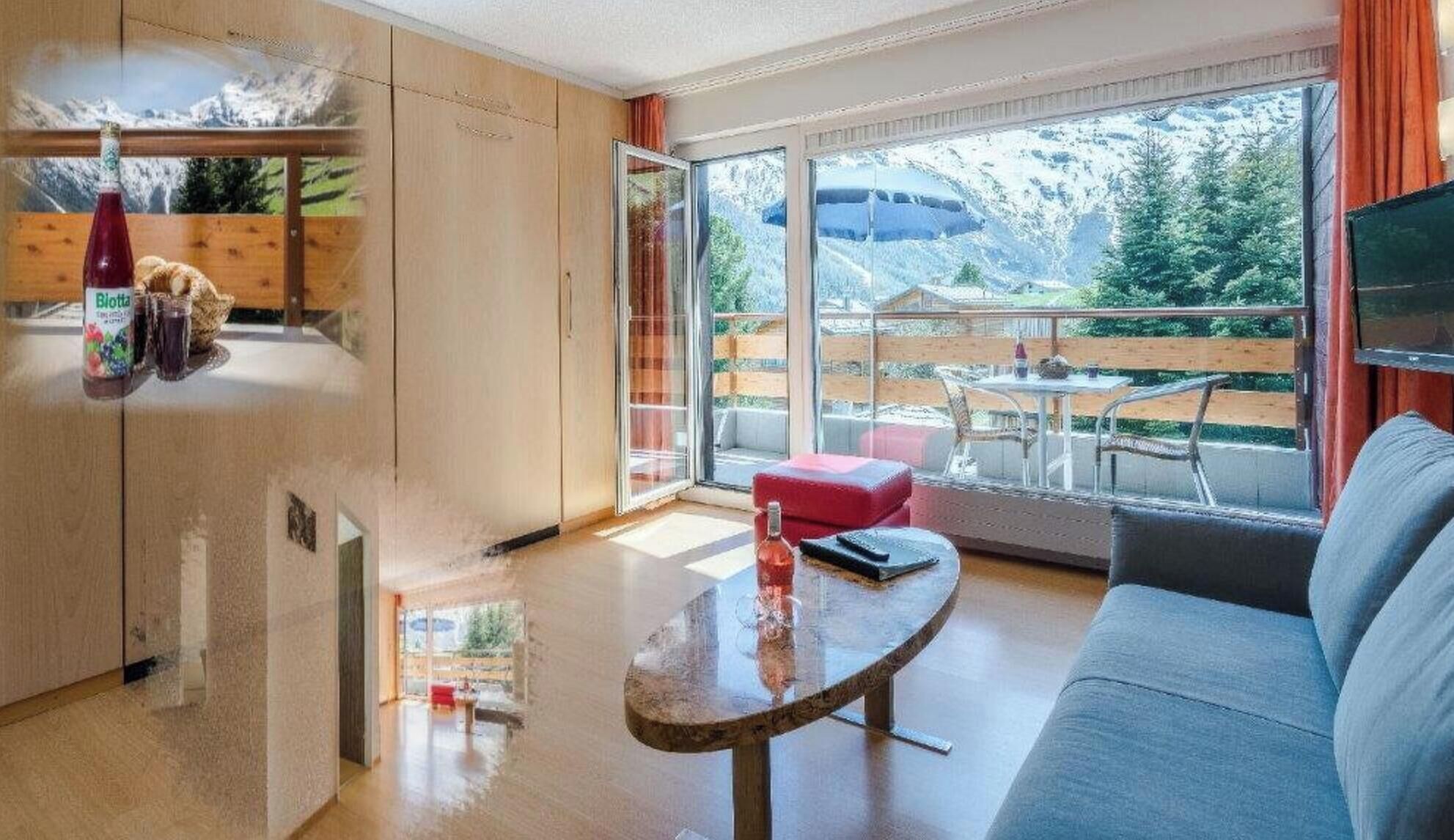 A modern living room with a sofa, a glass coffee table, and a view of a balcony with outdoor furniture.