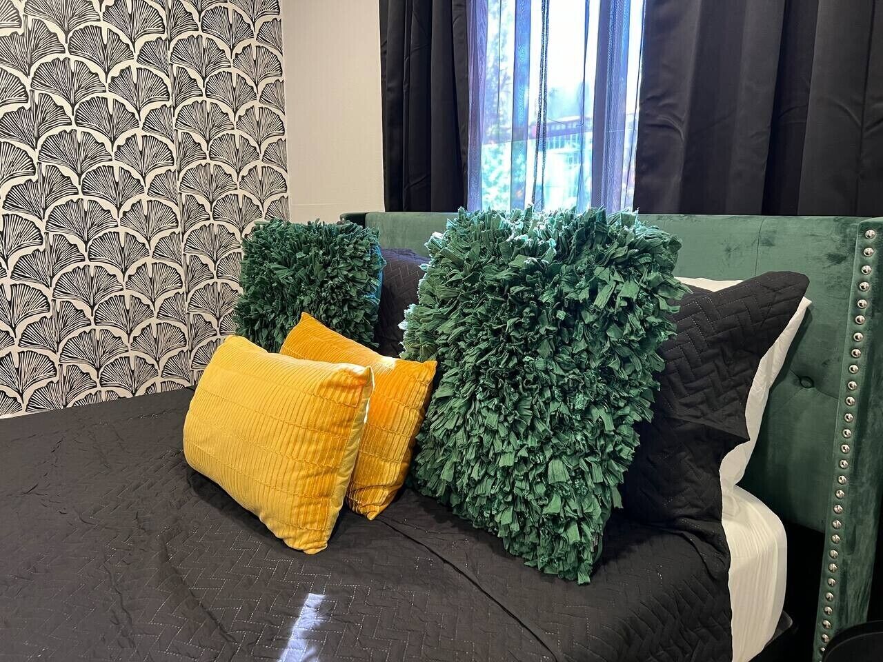 A bed with a patterned headboard, a dark brown mattress, and two yellow pillows.