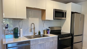 Uma cozinha moderna com lava-louças, fogão, micro-ondas e frigorífico.