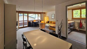 Ett modernt hotellrum med en matplats, en soffa, ett litet bord och utsikt över omgivningarna.