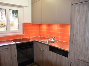 A modern kitchen with a dishwasher, sink, and wooden cabinets. - Acimo Appartement/Fewo 5-Bettwohnung Romeo & Julia by Interhome (Saas-Fee)
