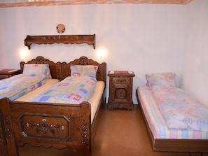 A bedroom with two wooden beds, a nightstand, and a wall-mounted shelf. - Acimo Appartement/Fewo 5-Bettwohnung Romeo & Julia by Interhome (Saas-Fee)
