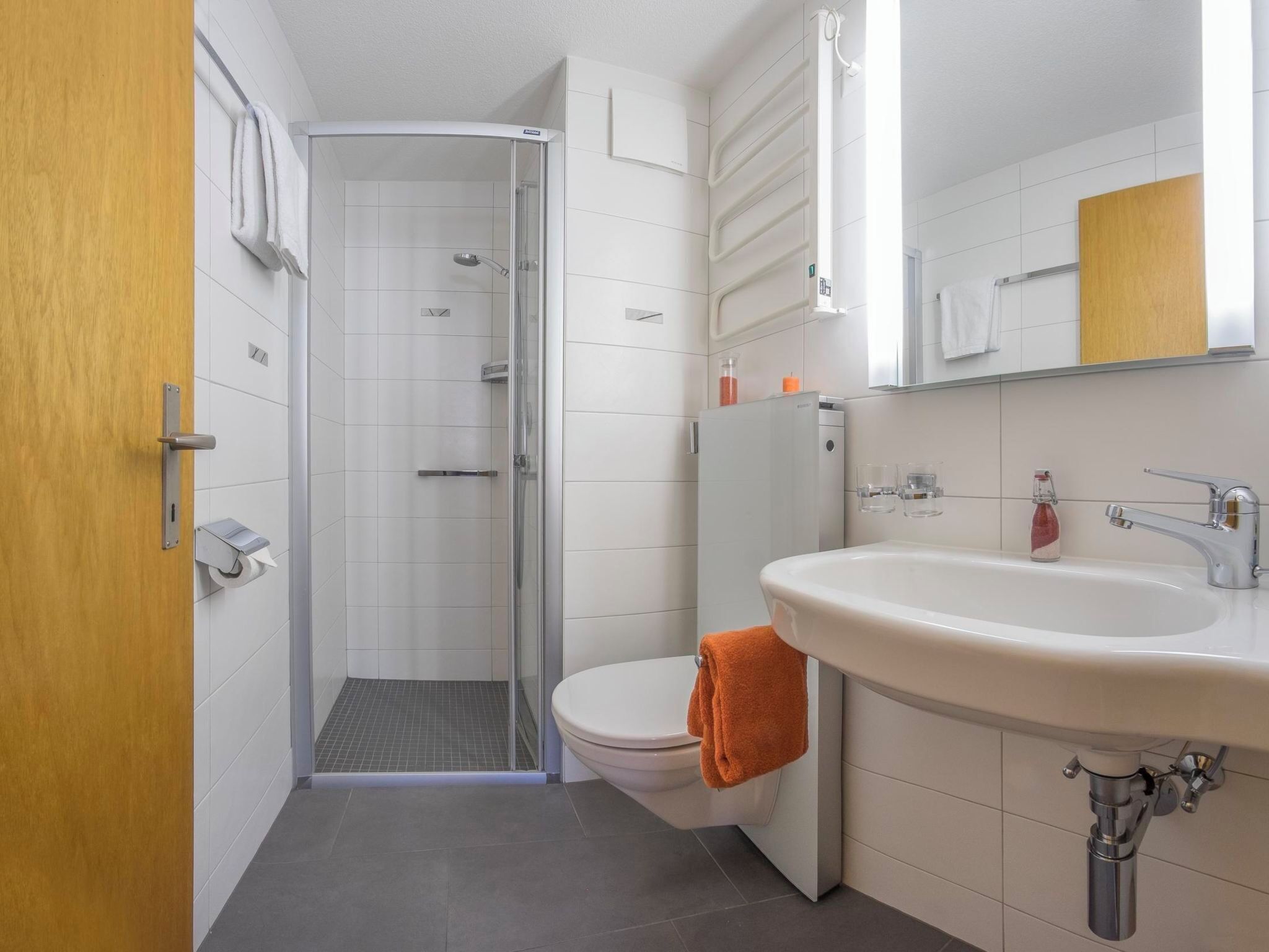 A bathroom with a shower, toilet, and sink.