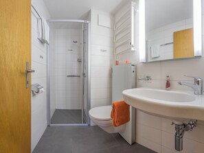 Ein Badezimmer mit Dusche, Toilette und Waschbecken.