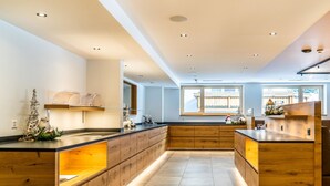 Cozinha moderna com armários de madeira, uma ilha central e uma grande janela que traz luz natural.
