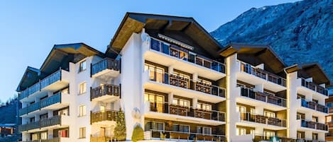 Ein mehrstöckiges Hotel mit Balkonen, einem Restaurant und einem Schild für einen Skiort.
