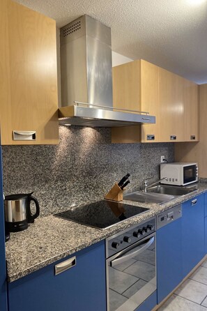 A kitchen with granite countertops, stainless steel appliances, and wooden cabinets. - Apartments Arcadia Appartement/Fewo 4-Bettwohnung Mittelgrat by Interhome (Saas-Grund)