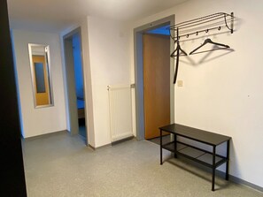 Ein Flur mit Heizkörper, einer Bank und einer Wäscheständer.