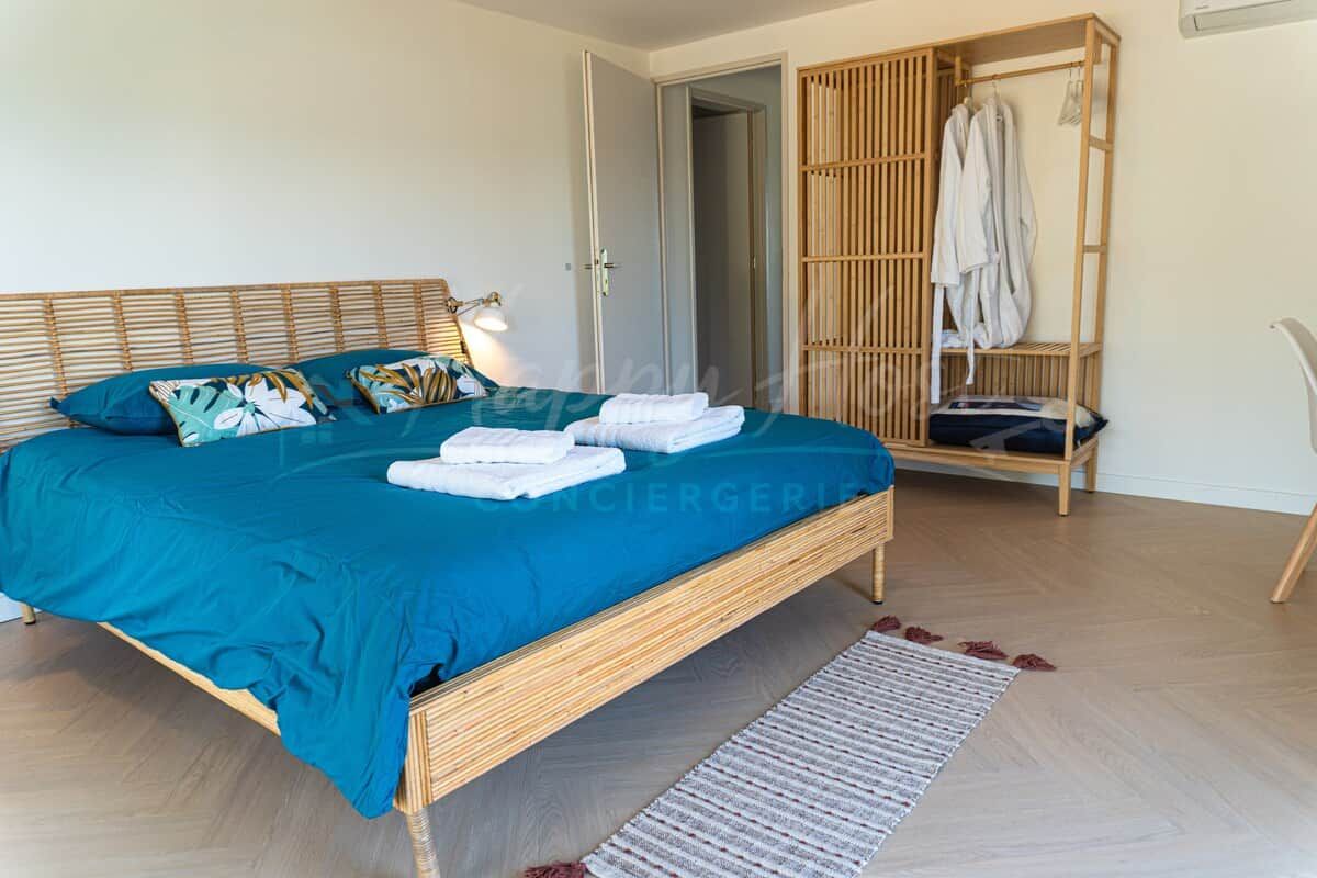 Un dormitorio con una cama, un armario y una silla.