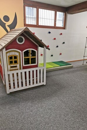 A playhouse with a white picket fence, a red roof, and two windows with yellow frames. - Ferienhaus Adonis Appartement/Fewo 5-Bettwohnung "Südlenz" by Interhome (Saas-Grund)