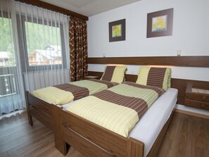Ein Doppelbett mit Holz Kopfteil, ein Nachttisch mit Lampe und zwei gerahmte Bilder an der Wand.