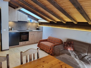 A compact kitchen with wooden cabinets, a countertop, and a built-in oven. - Apartments Atlas Appartement/Fewo Atlas 5 by Interhome (Saas-Grund)