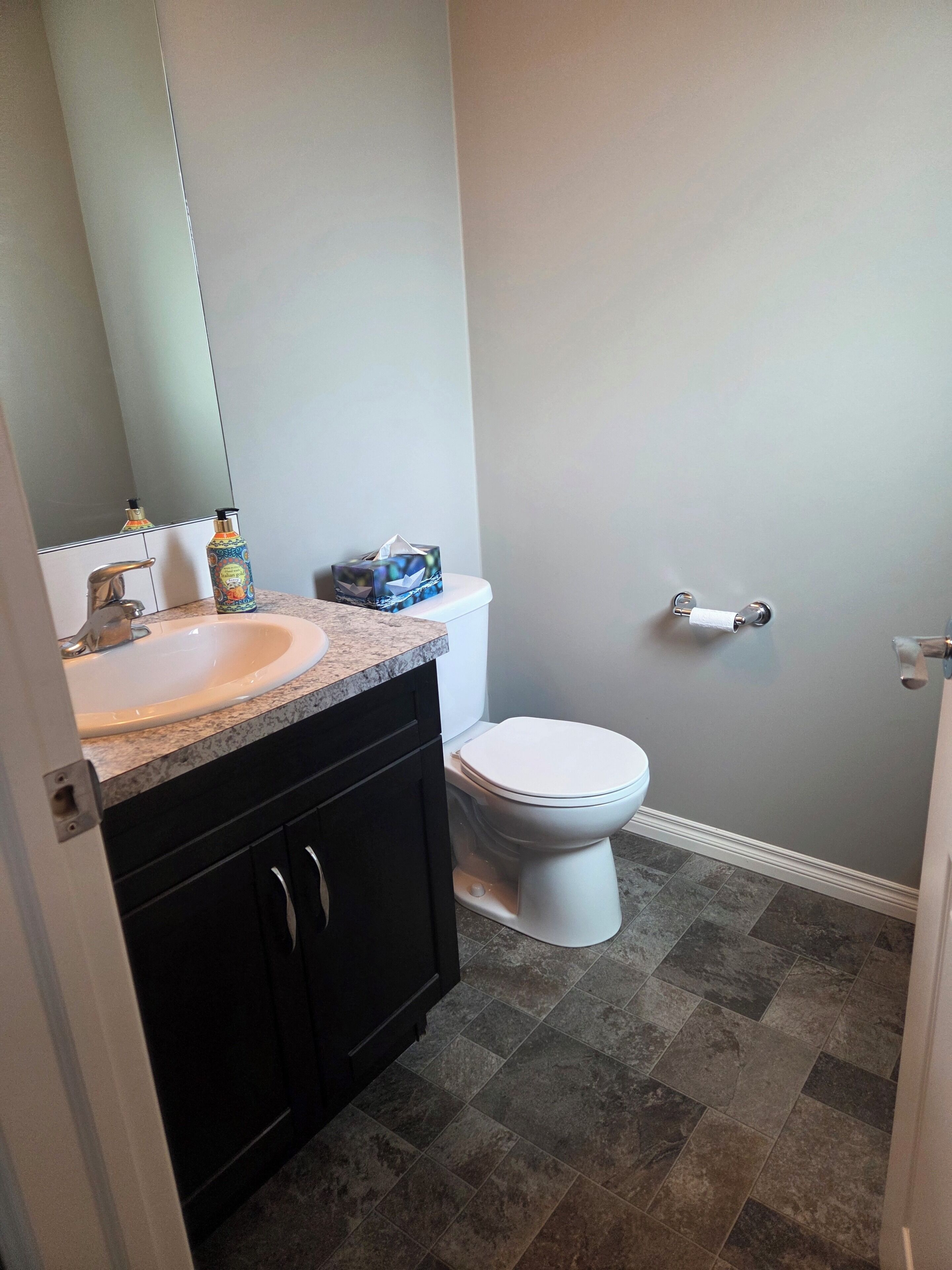 A bathroom with a sink, toilet, and a mirror.