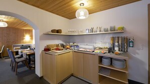 Une cuisine moderne avec des meubles en bois, un bar pour prendre le petit-déjeuner et une variété d'aliments pour le petit-déjeuner.