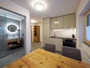 A compact kitchen with a dining area, a built-in oven, and a window. - Apartments Chesa Grischuna, (Samnaun-Dorf) by Interhome (Samnaun)