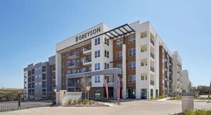 Ein mehrstöckiges Hotel Greyson mit modernem architektonischen Design, das Balkone und große Fenster aufweist.