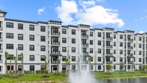Un edificio residencial de varios pisos con una fuente central.