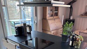 A modern kitchen with a black countertop, stainless steel appliances, and a built-in oven. - Ferienwohnung Gassmann Appartement/Fewo 4-Bett Wohnung mit Dusche, Bad u. Balkon by Interhome (Spiez)