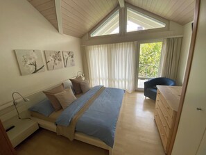 A bedroom with a bed, a desk, a chair, a dresser, and a window with curtains. - Ferienwohnung Gassmann Appartement/Fewo 4-Bett Wohnung mit Dusche, Bad u. Balkon by Interhome (Spiez)