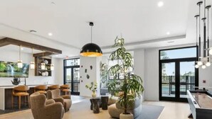 Amplia sala de estar con mesa de billar, asientos cómodos y un ventanal con vistas al exterior.