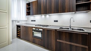 Eine moderne Küche mit dunklen Holzschränken, einer Edelstahl-Spüle und einem eingebauten Backofen.