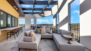 Een modern buitenterras met een modulaire bank, een eettafel en stoelen.