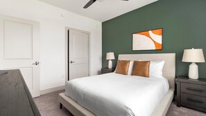 Ein Schlafzimmer mit einem Bett, Nachttischen, einem Deckenventilator und einem Gemälde an der Wand.