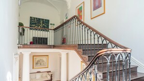 Una maestosa scala con ringhiera in legno e balaustre in metallo, che conduce a un piano superiore.