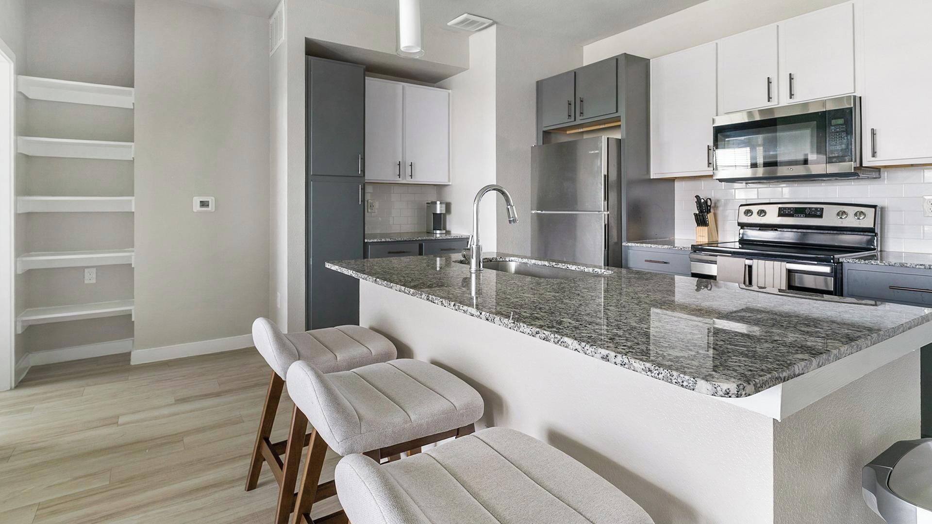 A modern kitchen with a granite countertop, stainless steel appliances, and a built-in oven.