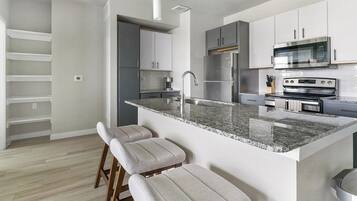 A modern kitchen with a granite countertop, stainless steel appliances, and a built-in oven.