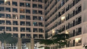 A nighttime view of a high-rise building with a swimming pool. - Mall of Asia - Asian Budget Stays (Pasay City)