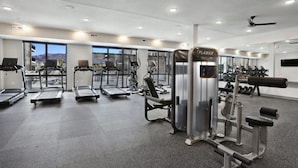 Een moderne sportschool met loopbanden, elliptische trainers en gewichthefapparatuur.