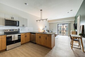 Una cocina moderna con gabinetes de madera, microondas integrado y lavavajillas.