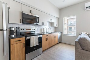 Una cocina moderna con horno integrado, microondas y electrodomésticos de acero inoxidable.